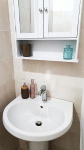 a white sink in a bathroom with a mirror at Coffee&Tea House Casetta Tipica a 5min dal centro storico in LʼAquila