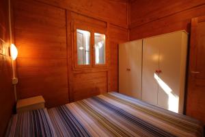 a bedroom with a bed in a wooden room at CAMPING CALATELLA parco di vacanza in Marina di Massa