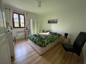 a bedroom with a bed and a chair and a window at Lilas - Spacieuse maison 10 pers Jardin BBQ in Doumen