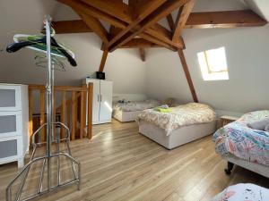 a room with two beds and a wooden floor at Lilas - Spacieuse maison 10 pers Jardin BBQ in Doumen +12 photos