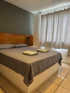 a bedroom with a bed with two pillows on it at Sonhos ML ApartHotel in Búzios