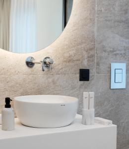 a bathroom with a white sink and a mirror at The Residence Aiolou Hotel & Spa in Athens