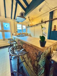 a kitchen with a counter and stools in a room at The Thomas Tripp Pub - The Tripp Upstairs - Two Bedroom Apartment in the Heart of Christchurch in Christchurch