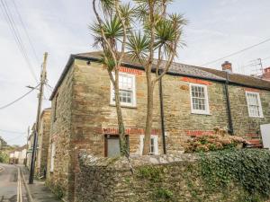 ein Backsteinhaus mit Palmen davor in der Unterkunft Boatman's Cottage in Salcombe