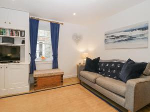 ein Wohnzimmer mit Sofa und Fernseher in der Unterkunft Boatman's Cottage in Salcombe