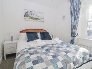 ein Schlafzimmer mit einem Bett mit einer karierten Decke in der Unterkunft Boatman's Cottage in Salcombe