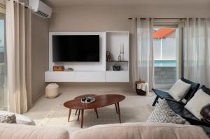 ein Wohnzimmer mit Sofa und Fernseher in der Unterkunft Luxury Villa Lovre seaside heated pool sauna in Nin