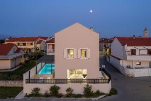 eine Luftaufnahme eines weißen Hauses mit Pool in der Unterkunft Luxury Villa Lovre seaside heated pool sauna in Nin