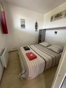 una camera da letto con un letto e un asciugamano rosso sopra di T2 Bord de plage, résidence Bleu Marine 46 a Lacanau-Océan