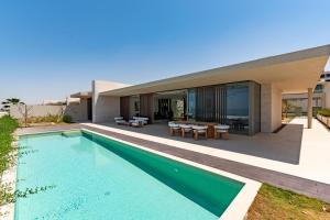 a swimming pool in front of a house at Ajman Villa, Exclusive 21 Al Zorah - Mint Stay in Ajman 
