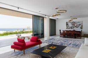 a living room with a red chair and a table at Ajman Villa, Exclusive 21 Al Zorah - Mint Stay in Ajman  +38 photos