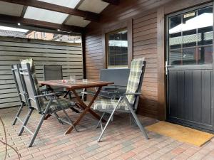 a wooden table and chairs on a patio at Ferienhaus Walddomizil in Neustadt-Glewe +7 photos