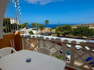 a balcony with a table and a view of a city at Panoramic Paradise Tenerife Ocean View & Comfort in Adeje