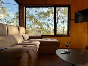 a living room with a couch and a table and a window at Richmond Wildlife Haven in Richmond