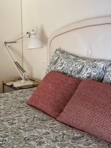 a red pillow sitting on a bed with a lamp at Luxury Penthouse with 2 Pools in a Monastery in Tavira +53 photos