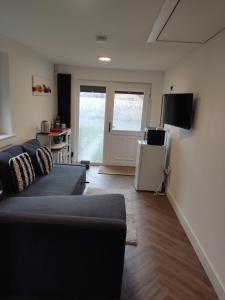 a living room with a couch and a television at En-suite double room with private entrance in Edinburgh
