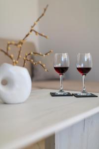 two glasses of red wine sitting on a table at Stella's Apartment Karfas in Karfas