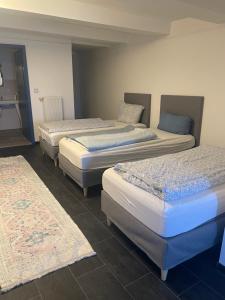 three beds in a room with mats on the floor at Aydogan Vermietung in Stade