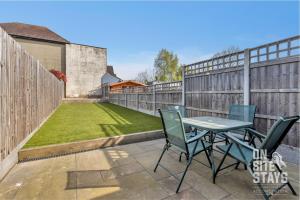 a patio with a table and chairs on a fence at OnSiteStays - Large 3 bedroom, 2 bathroom, driveway, Garden, Sleeps 6 Comfortably in Bexleyheath