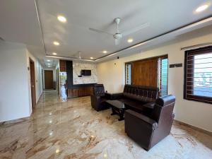 a living room with a couch and a table and chairs at HOTEL MADHAVA RESiDENCY in Kākināda