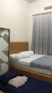 a bedroom with two beds and a mirror at Bundarooms Homestay Mibo in Geutieue