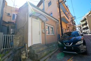 a car parked next to a building with a door at Liora Retreat in Kavála