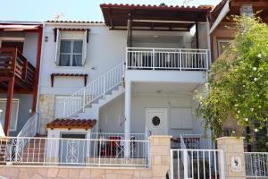 a white house with a staircase in front of it at Polymnia's Home in Áyios Andónios