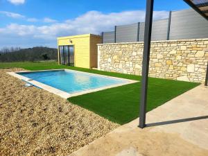une piscine dans la cour d'une maison dans l'établissement Gîte de charme L'Escale Des Sens sauna et jacuzzi privé sud Ardéche, à Bessas