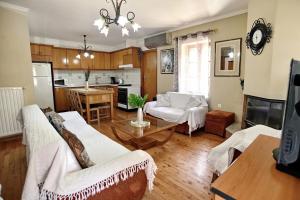 a living room with two white couches and a kitchen at Prokopis House in Sívros