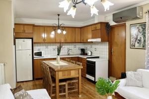a kitchen with wooden cabinets and a white refrigerator and a table at Prokopis House in Sívros