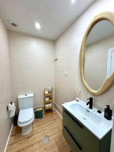 een badkamer met een toilet, een wastafel en een spiegel bij Azahar Homes - Murcia Centro in Murcia +4 foto's