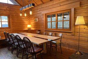 a dining room with a wooden table and chairs at Schwarzwald Blockhaus - Sauna - Kamin - mit Bettwäsche und Handtücher in Schenkenzell