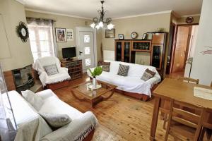 a living room with white couches and a table at Prokopis House in Sívros