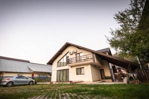 a house with a car parked in front of it at Happy Home in Călimăneşti