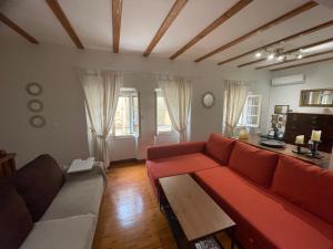 a living room with a red couch and a table at Grandma’s old town house in Corfu Town
