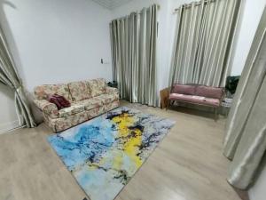 sala de estar con sofá y alfombra colorida en Homestay Al Ayyubi Medan Jaya, en Marang