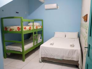 a bedroom with a bunk bed and a green bunk bed at Chalés Panulirus in Icapuí