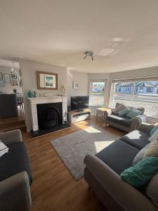 a living room with a couch and a fireplace at Coastal Escape - Portballintrae in Portballintrae