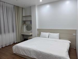 a bedroom with a large white bed and a window at Tom and Jerry Hotel in Kon Rung (1)