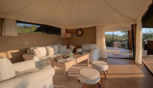 un soggiorno con un divano e un tavolo di Kicheche Valley Camp a Naboisho Altre 11 foto
