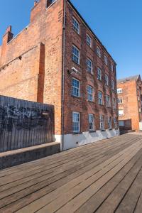 a brick building with a wooden boardwalk in front of it at The Old Embassy by Guestz in Hull