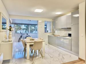 a kitchen with white cabinets and a table and chairs at Vibrant Host Solutions - Póvoa Living in Póvoa de Varzim +13 photos