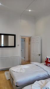 a bedroom with two beds and a tv on the wall at Cozy Apartment Sleep 5 in Berkely BK3 in London +2 photos