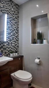 a bathroom with a toilet and a sink and a mirror at Cozy Apartment Sleep 5 in Berkely BK3 in London