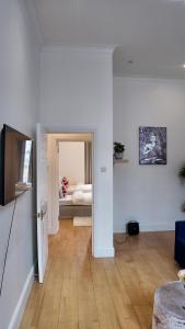 a living room with white walls and wooden floors at Cozy Apartment Sleep 5 in Berkely BK3 in London