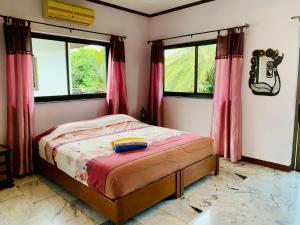 a bedroom with a bed in a room with windows at Big Villa 3 at CET Resort Rayong Padelcenter in Klaeng