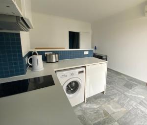 a kitchen with a washing machine in a kitchen at L'Astrolabe - Studio - refurbished - seaside in Cannes +10 photos