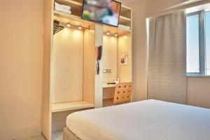 a bedroom with a bed and a flat screen tv at Hello Hotels Bucuresti Gara de Nord in Bucharest +44 photos