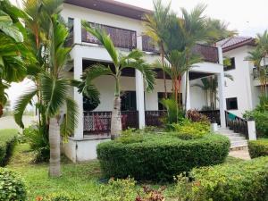 a house with palm trees in front of it at Big Villa 3 at CET Resort Rayong Padelcenter in Klaeng