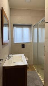 un bagno con lavandino e doccia in vetro di Margarida Guest House ad Almada Altre 17 foto